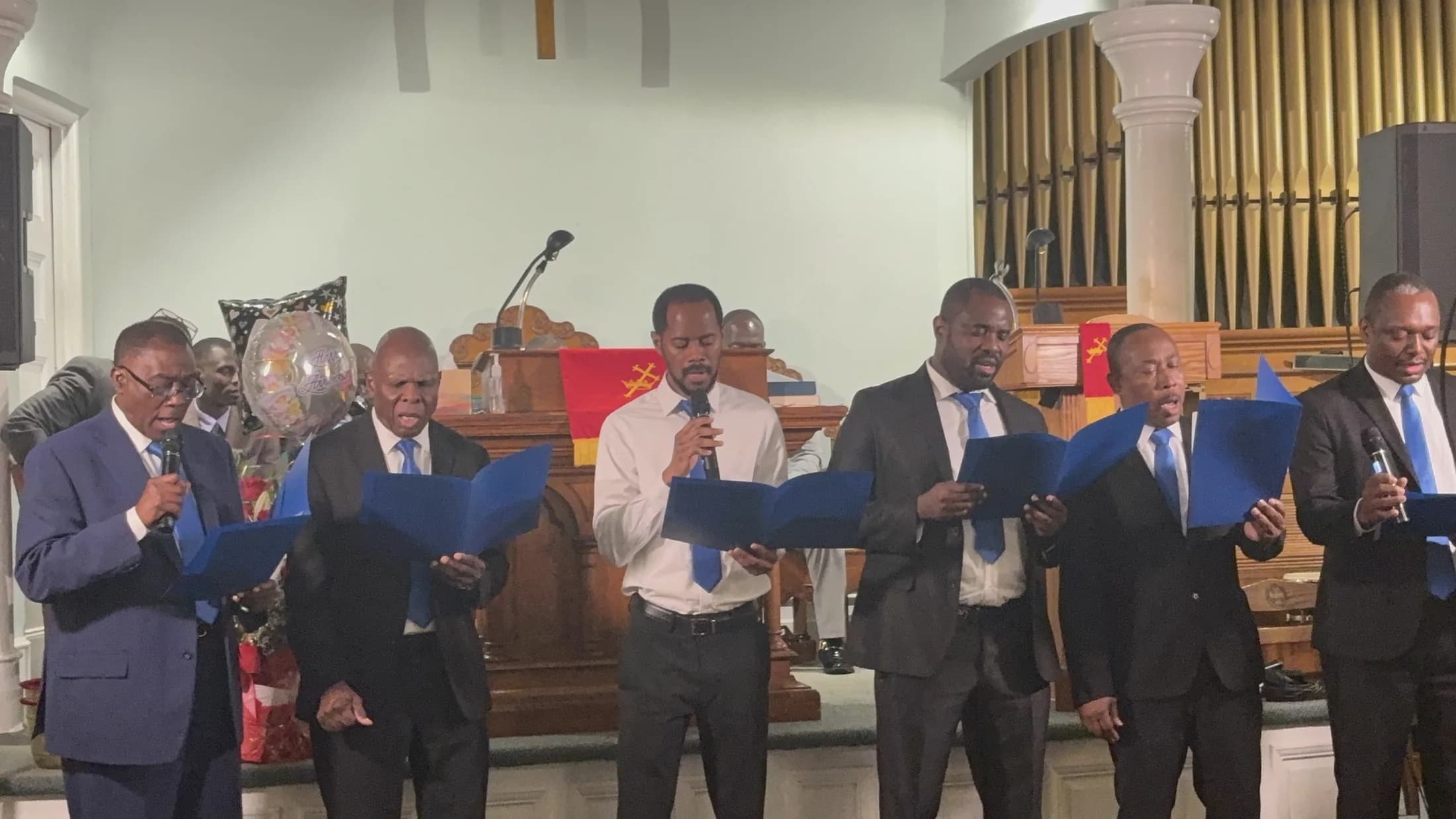 The men's choir singing together during worship