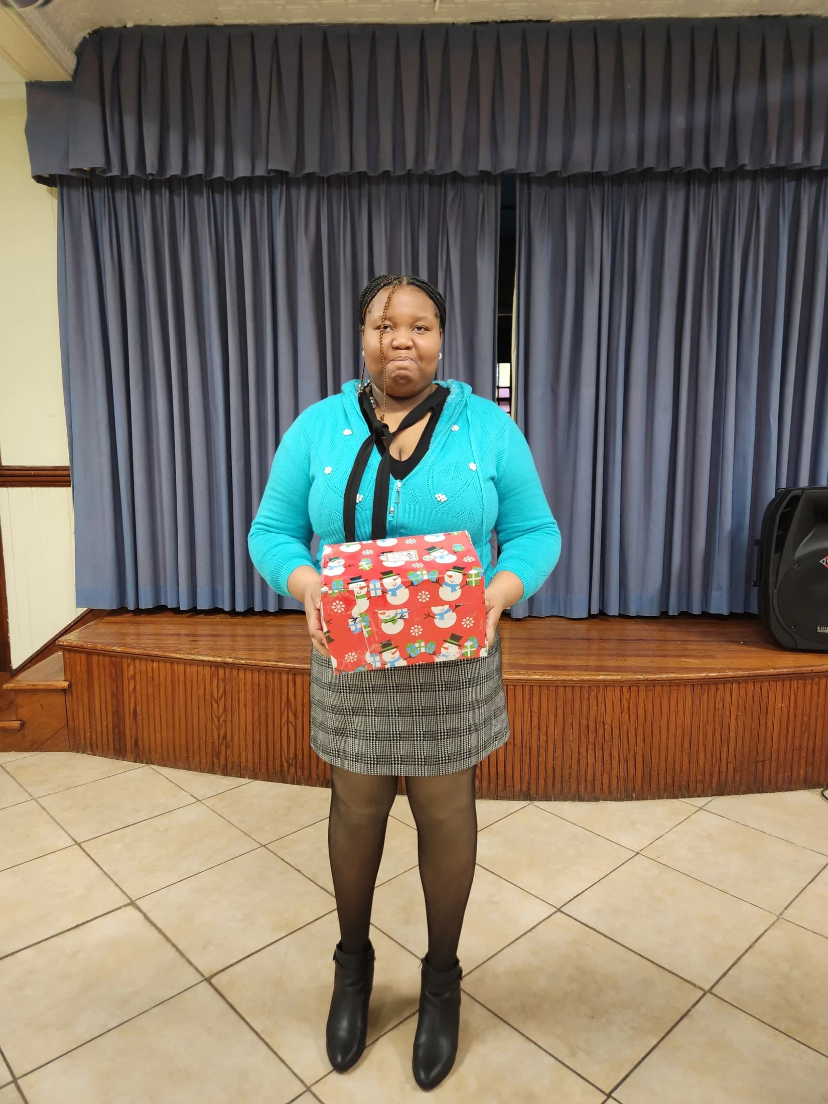 A woman from the EBRC family holding a Christmas gift