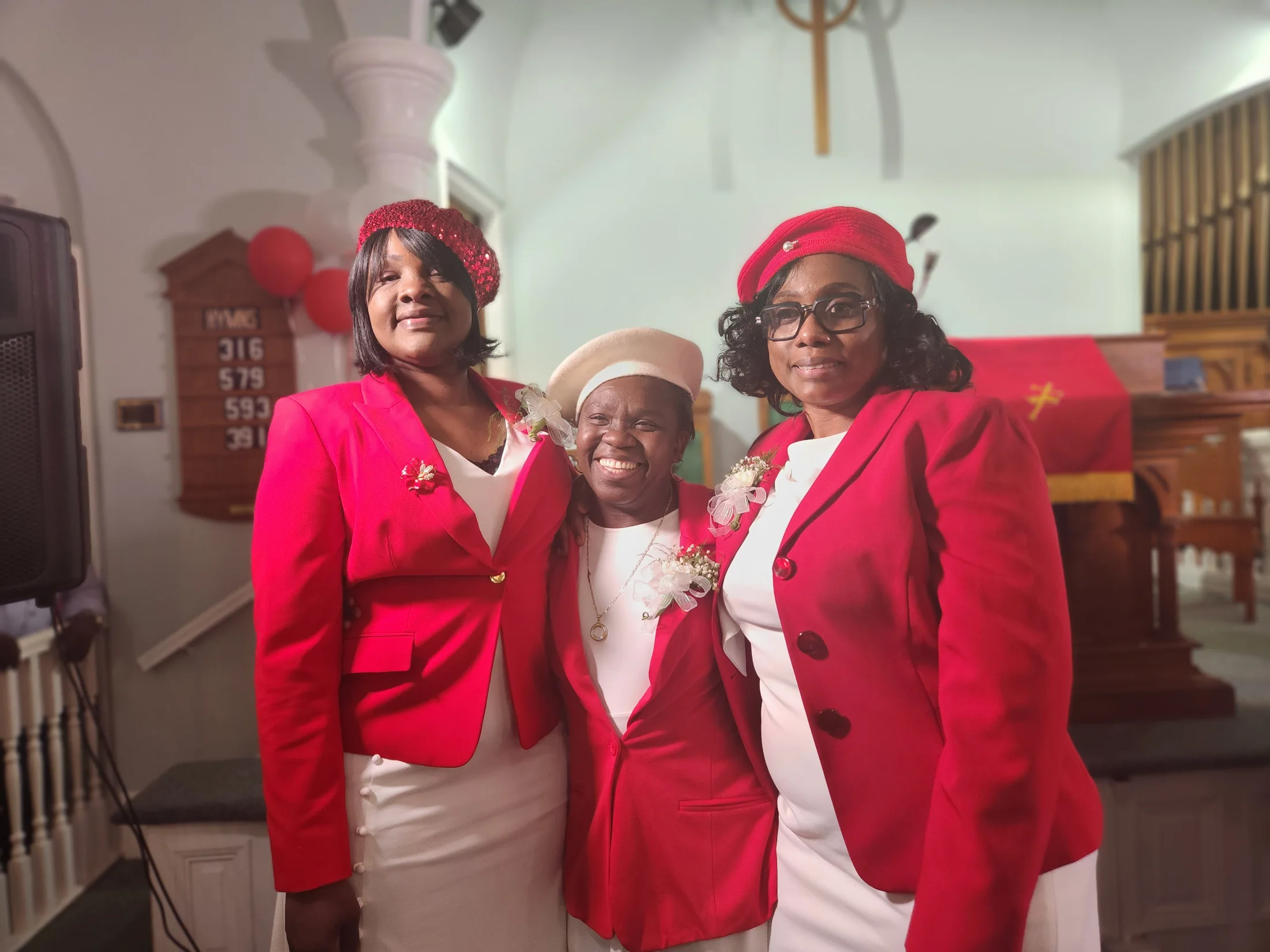 Three smiling women celebrating the church inauguration
